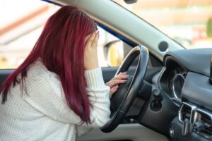 Woman Holding Head in Pain After Car Accident