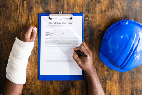 An injured worker in a medical facility discussing their workers compensation claim with medical providers and family members about lost wages and workers compensation insurance benefits.